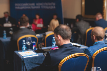 Audience at the modern conference hall listens to lecturer, people on a congress together listen to...