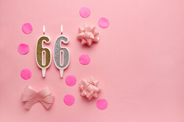 Number 66 on pastel pink background with festive decor. Happy birthday candles. The concept of celebrating a birthday, anniversary, important date, holiday. Copy space. banner