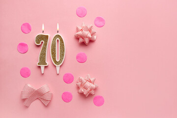 Number 70 on a pastel pink background with festive decor. Happy birthday candles. The concept of celebrating a birthday, anniversary, important date, holiday. Copy space. banner