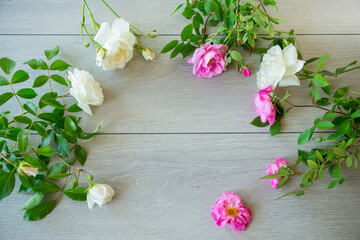 Floral background of pink and white roses on a light wooden