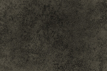 Dark background of decorative plaster with abstract spots. Unusual black or gray wall texture with beautiful patterns, creative surface background. Finishing coating for building cladding.