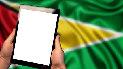Man hold tablet phone pc gadget with white blank screen, copy space for text, image or message. Flag of Guyana country on background. Technology, information, business

