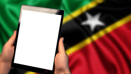 Man hold tablet phone pc gadget with white blank screen, copy space for text, image or message. Flag of Saint Kitts and Nevis country on background. Technology, information, business
