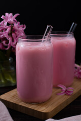 Strawberry milkshake and pink hyacinths on the table