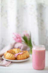 Strawberry milkshake, cakes and pink hyacinths