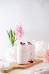 Two glasses with a cocktail of pink color with glass tubes
