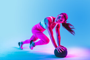 Sportive woman training on a colorful background - Athletic fit adult female doing functional...