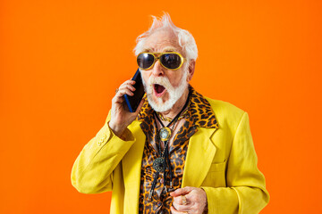 Cool senior man with fashionable outfit portrait - Old and funny grandfather wearing stylish and colorful clothing portrait on colored background - obrazy, fototapety, plakaty