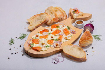 Trendy Butter Board with salmon, red onion, mustard and fresh dill. Homemade snack with baguette