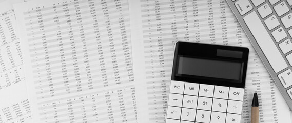 Calculator near laptop on financial documents. Top view.