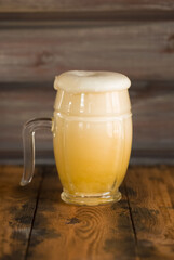 A mug of foamy beer close-up on a wooden table in a pub. Glasses of light and dark beer with foam.