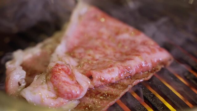 Close-up footage of a large A5 Wagyu slice on the grill, watch as the marbled perfection sizzles and caramelizes, creating a symphony of flavors that will captivate your senses. 