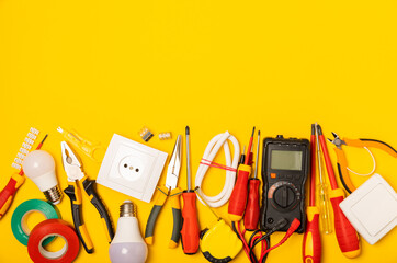 Electrician equipment on yellow background with copy space.Top view.Electrician tool set.Multimeter, tester,screwdrivers,cutters,duct tape,lamps,tape measure and wires.Flet lay. © Avocado_studio
