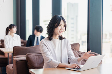 シェアオフィスでノートパソコンを使うビジネスウーマン