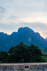 Mountain as the sun sets. Mountain peak green nature scenery. Beautiful sunset over the mountain range at vang vieng.