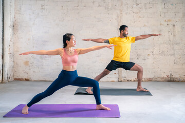 Mixed race sporty man and girl doing exercise. Multi ethnic couple On Mats Doing Yoga Exercises Together. High quality photo