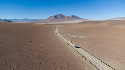 Fototapeta na wymiar A green campervan on a dusty road in the middle of the Andes