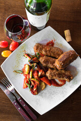 Fried Chicken with vegetables with some tea and wooden table