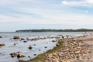 Fototapeta na wymiar Steine am Strand der Ostsee vor Baabe mit Blick in Richtung Göhren auf Rügen