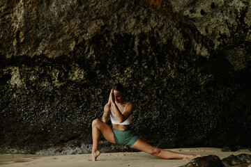 Flexible fit girl exercising by the ocean, fit woman doing leg stretch asana pose keeping vitality...