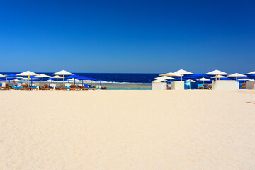 Sunny beach with umbrellas on the Red Sea in Marsa Alam, Egypt