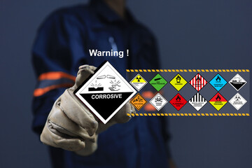 Staff with glove holding the corrosive sign one of dangerous substance or goods in the worning list...