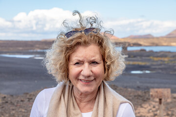 portrait of attractive elderly woman in nature with wind in hair