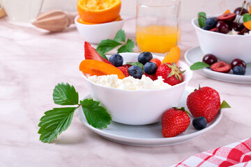 Cottage cheese with strawberry, blueberry and apricot in a bowl and a glass of orange juice. Healthy breakfast