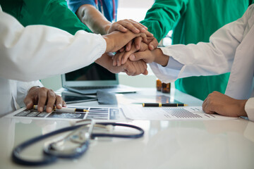 The medical team joins hands after the meeting and discusses the treatment of severely ill patients...
