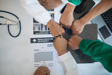 The medical team joins hands after the meeting and discusses the treatment of severely ill patients...