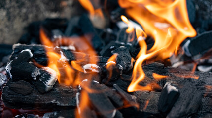 Fire, ember of charcoal on a grill. Close-up of glowing charcoal and hot embers. Barbeque time during summer. Heat, temperature, barbecue time.