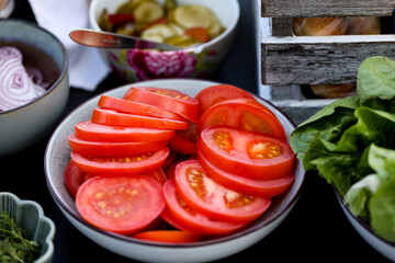 Fototapeta Sliced tomatoes laying in the bowl. Red tomato ready to eat. obraz