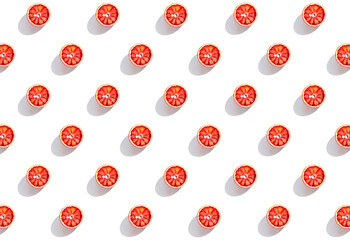Creative pattern made with half of blood orange on white background with shadow. Summer fruit and...