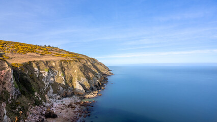 View of green heather fields, the Baily Lighthouse and the Irish Sea seen from the Howth Summit in Howth, near Dublin, Ireland