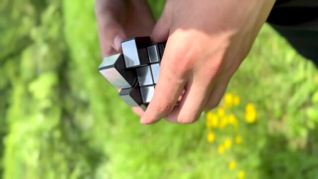 hands fold a rubik's cube from different shapes