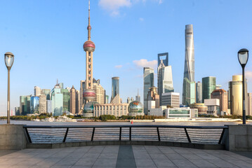 Shanghai skyline featuring modern buildings cityscape of Lujiazui, seen from the bund, view between two lamp posts and over railings