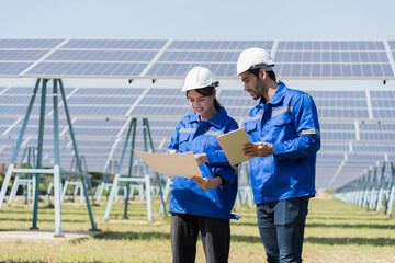 Male and female engineer worker working in solar panels power farm. Two technician working at solar power station