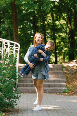 Fototapeta premium Caucasian mom having fun with her little son in the summer in the park