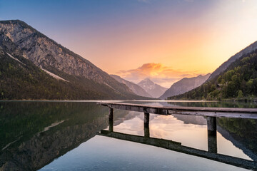 beautiful sunset at the natural jewel plansee in reutte in tyrol with reflection in the crystal clear mountain lake