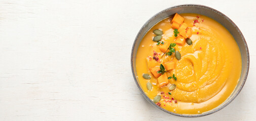 Pumpkin traditional soup with creamy silky texture on a white background.