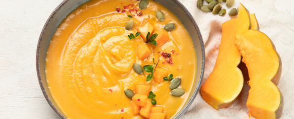 Pumpkin traditional soup with creamy silky texture on a white background.