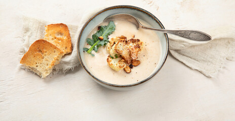 Roasted cauliflower soup served with grilled bread.