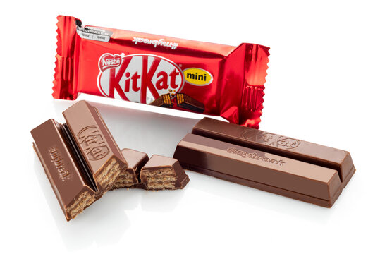 Italy - 2 June 2023: Kit Kat mini Nestle chocolate-covered wafer bar, created by Rowntree England, packet with whole and cut bar, isolated on white, clipping path