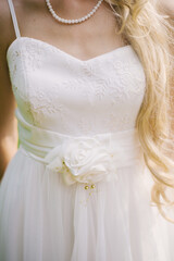 Fototapeta na wymiar Part of a wedding dress with a flower belt worn by the bride