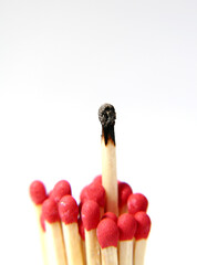 A bunch of matchsticks with one jutting out and burnt