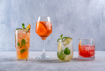Various alcoholic cocktails on grey background. Aperol spritz, Mojito, Negroni. Summer cocktails...