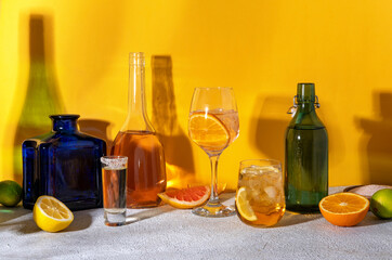 Various alcoholic cocktails on yellow background with sunlight shadows. Summer cocktails menu. Summer alcoholic cocktails for party. Hard light and shadow pattern