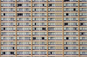Fototapeta na wymiar A section of a very monotonous apartment building. Many windows with curtains can be seen.