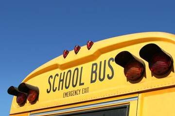 The tail lights of a yellow school bus.