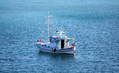 Traditional fishing boat, trawler moored, rippled sea water background, Greece